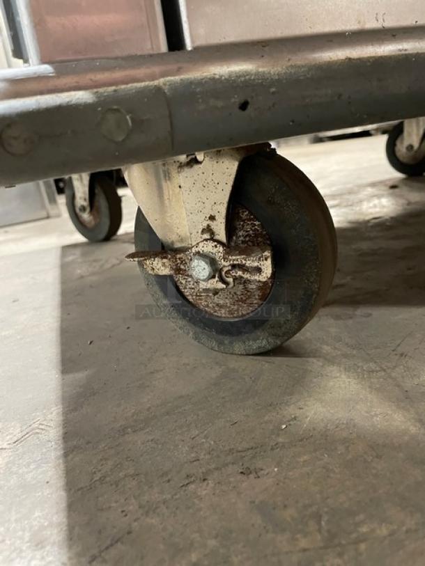 Cres-Cor commercial stainless steel heated cabinet caster with rubber bumper guard, showing signs of use.