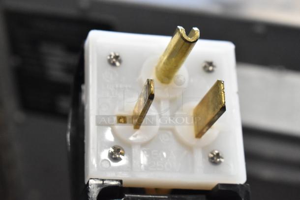 Close-up of a 250V plug for a Turbochef HhC1618 conveyor oven, showing three brass prongs in a white plastic housing.