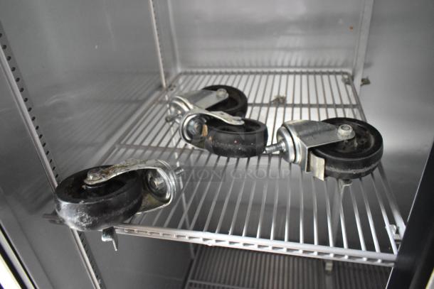 2016 True T-35 stainless steel cooler interior with poly-coated racks and detached commercial casters visible.