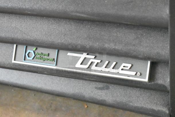 2024 True GDM-26-HC commercial cooler detail showing brand logo and "natural refrigerant" label.