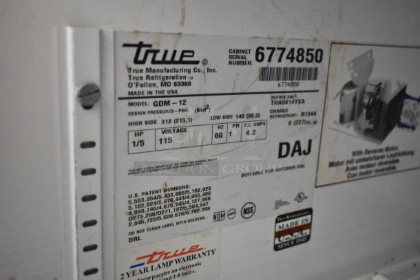True GDM-12 metal commercial cooler label, indicating model, voltage (115V), phase (1), and various design specs.