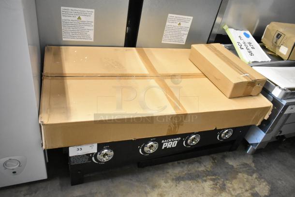 Brand new Backyard Pro 36" steel propane griddle, 60,000 BTU, minimalist design, some packaging wear. Marked "Backyard Pro."