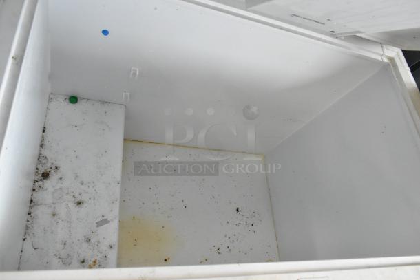 Kenmore 253.16342105 chest freezer with hinge lid, interior view. Some dirt visible, indicating need for cleaning. 115 volts, 1 phase.