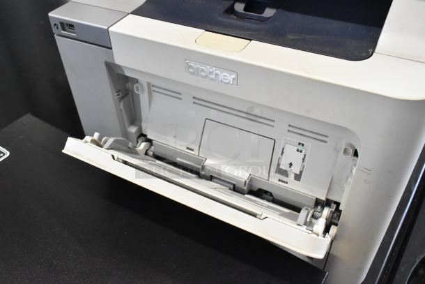 Brother MFC-9440CN printer, scanner, copier, fax machine with open paper tray. Silver finish, visible Brother logo.