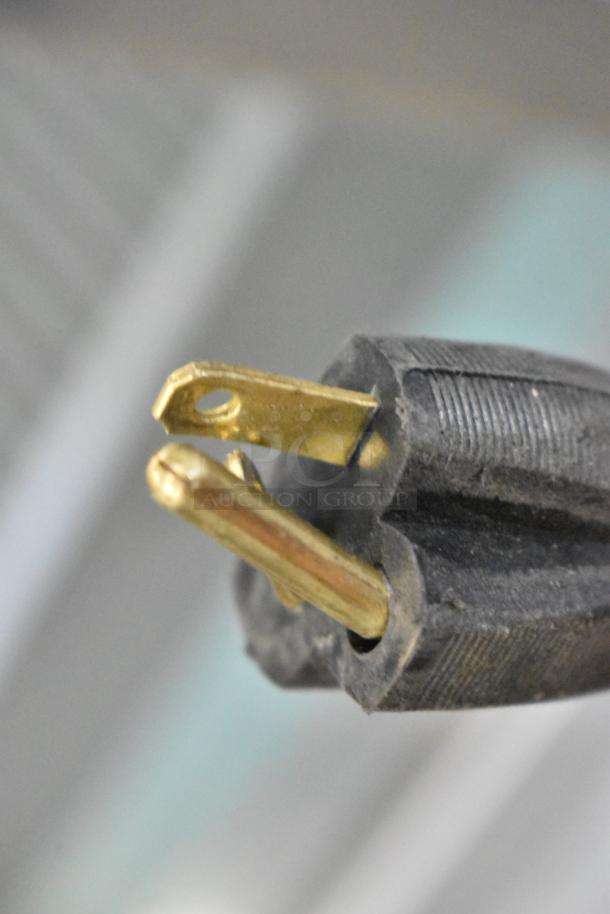 Close-up of a plug from the 2024 Bunn SINGLE SH DBC coffee machine. Dual prongs, black plastic body.