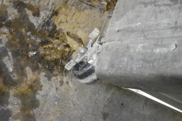 Dirty wheel with a metal bracket on a worn floor, possibly part of the Turbo Air TSF-49SD freezer. Condition not ideal.