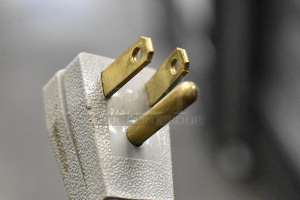 True GDM-41SL-60-LD cooler plug, close-up. Brass prongs, textured surface. 115V, 1 Phase.