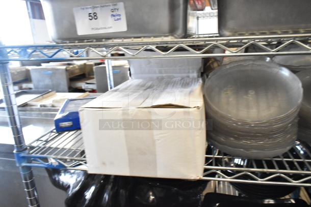 Metro lot of stainless steel drop-in bins, chafer lids, salad plates, and bowls on a metal shelf. PCH Auctions tag visible.