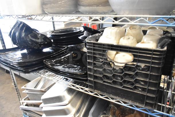 Metro lot with stainless steel drop-in bins, chafer lids, black salad plates, and bowls on metal shelf. No shelving unit.