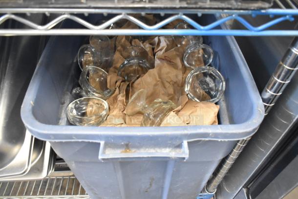 Assorted glass bowls in a blue bin with brown paper packaging; part of a lot including stainless steel items.
