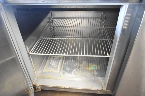 2018 Continental CPA93 stainless steel pizza prep table with shelving. Visible wear on interior. 115 volts, 1 phase.