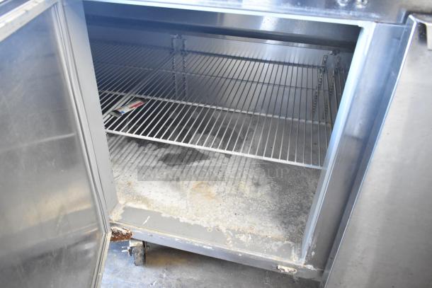 2018 Continental CPA93 stainless steel pizza prep table, open door view showing shelves and interior condition. Commercial casters visible.