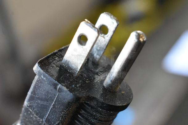Close-up image of a three-prong electrical plug belonging to a metal countertop food warmer.