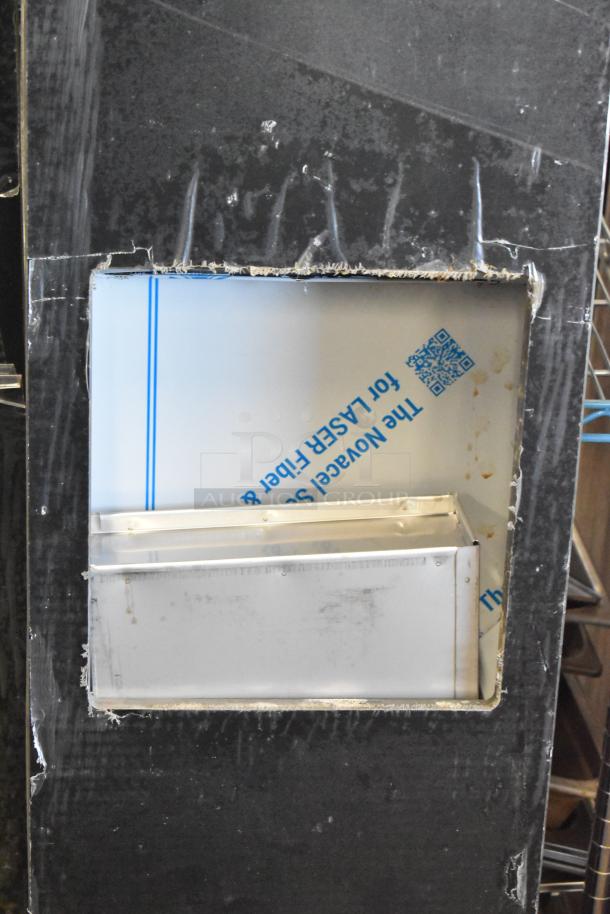 Two metal units with visible protective film, mounted on a black board, showing minor wear and industrial design.
