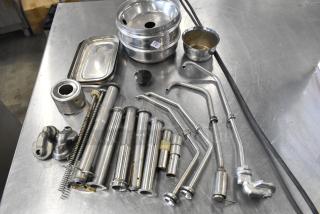 Lot of various metal items including server pump parts. Items show signs of wear. Auction tag visible on bowl.
