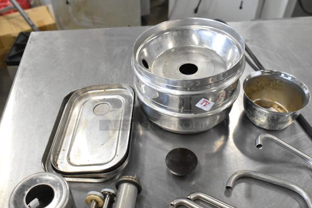 Lot of stainless steel server pump parts, including various bowls, lids, and metal tubes, showing light wear.