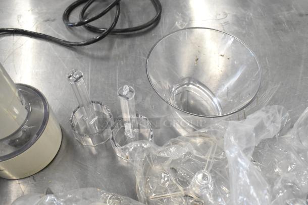 Waring food processor with plastic components, 2 S blades, 6 slicing blades, and 1 grating blade. 120 Volts, 1 Phase.