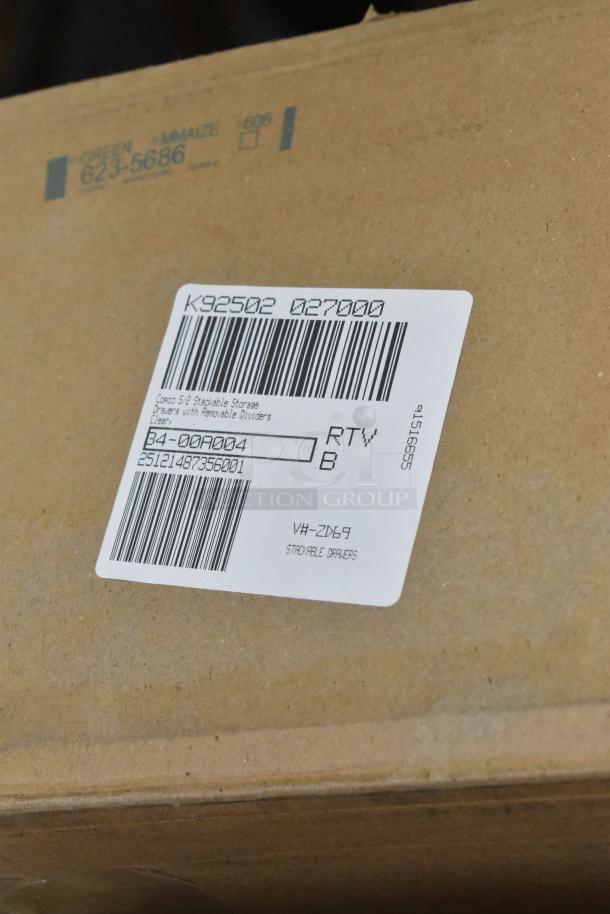 Cardboard box with label indicating "Copco S/2 Stackable Storage Drawers with Removable Dividers, Clear." Other items not visible.