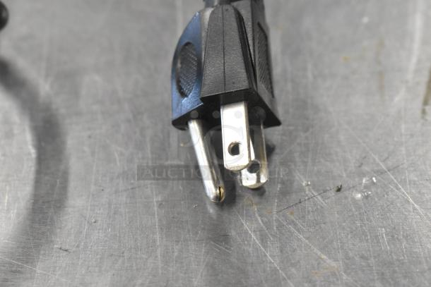 Close-up of a power plug for a Powervar Power Conditioner, featuring standard three-prong design on a metal surface.