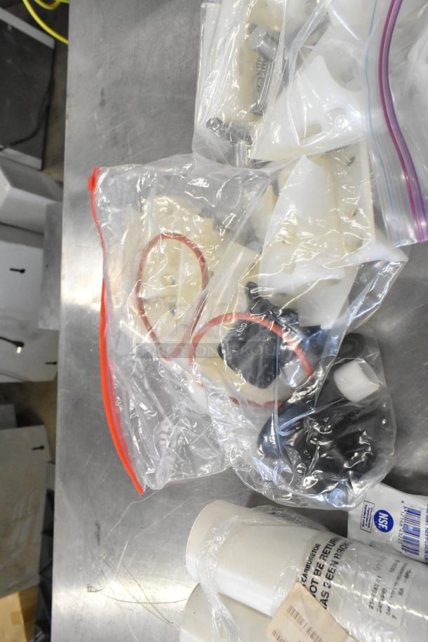 Lot of miscellaneous items in clear plastic bags, includes belts and various pieces. Condition appears unused.