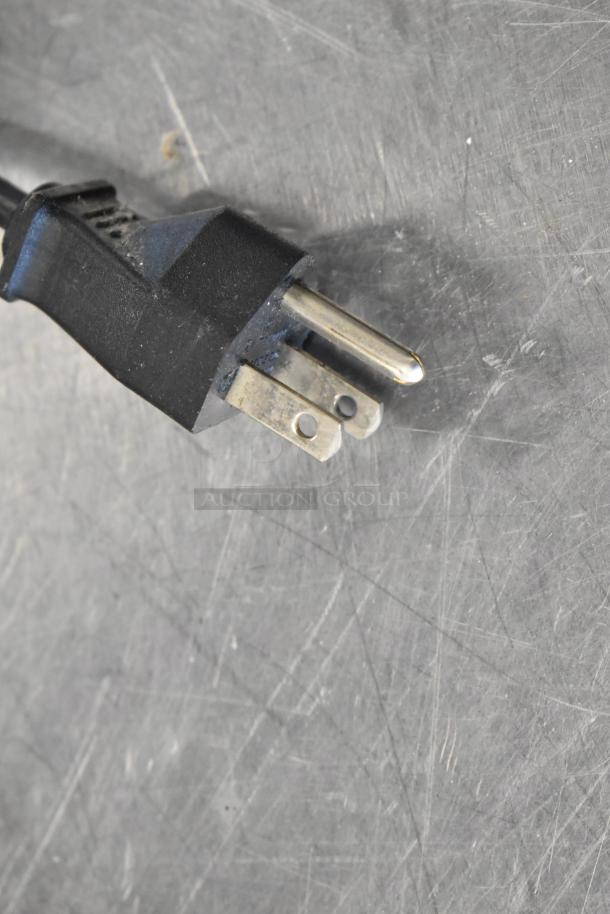 Close-up of a black power plug with three prongs.