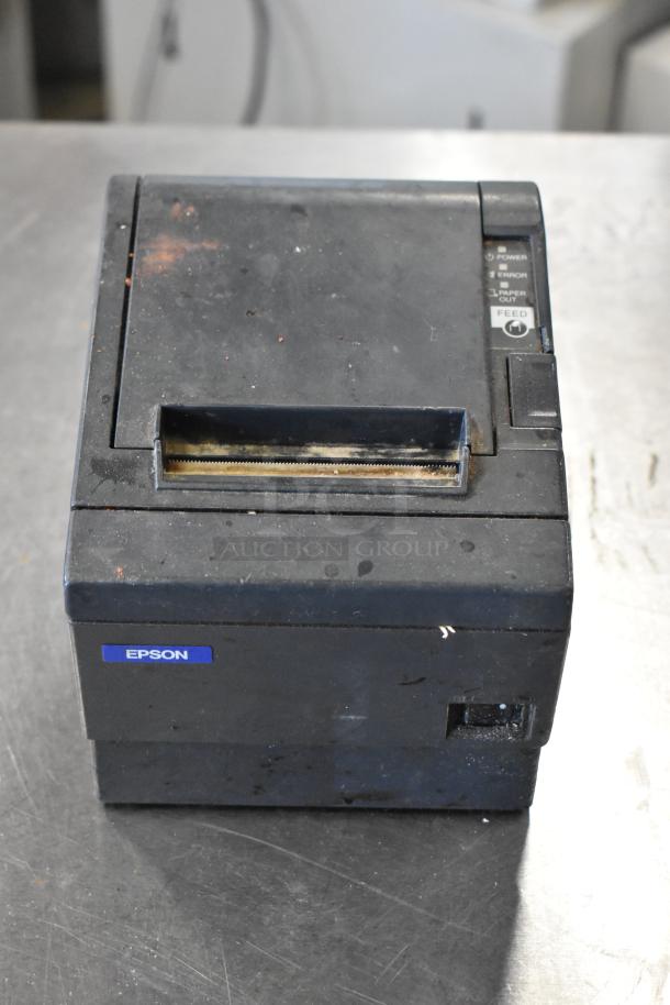 Epson receipt printer, black, worn condition, visible Epson label, feed and error indicators on panel.