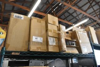 Auction lot of various brand new items, including egg dispenser, stackable storage drawer, and food chopper cup. Boxes are sealed with visible labels showing item numbers and site information.