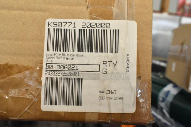 Cardboard box with a label showing "Corco 2-Tier Adjustable Kitchen Cabinet Shelf Organizer" and model number 30-00A021. Box is sealed and has a barcode.