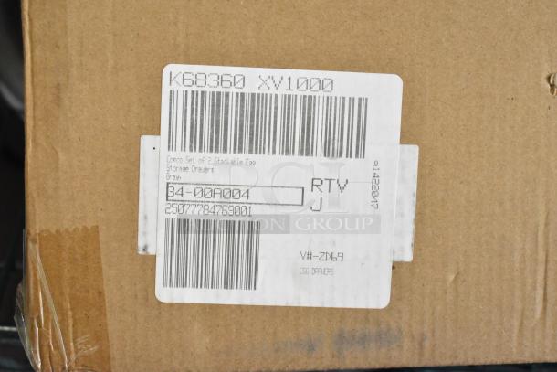 Cardboard box with label showing item details: "Comco Set of 2 Stackable Egg Storage Drawers, Gray." Barcodes visible.