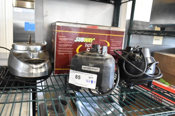 Four kitchen appliance bases, including two Hamilton Beach blender bases, a Cuisinart blender base, and a Nemco food warmer. 115 volts, 1 phase, condition varies. Auction lot tag visible.