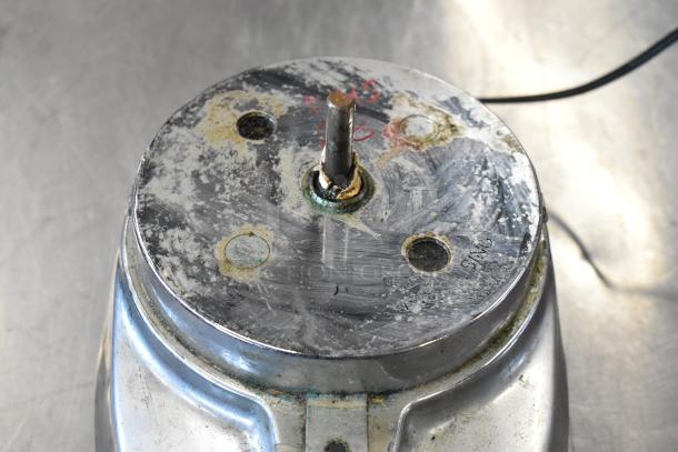 Hamilton Beach blender base, metal surface, visible wear and corrosion, electrical cord attached.