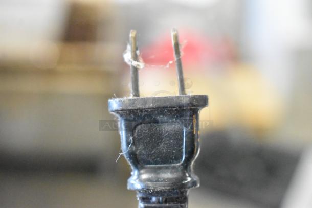 Close-up of a two-prong electrical plug from a kitchen appliance.