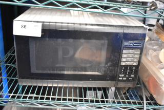 Sharp R-3A55 countertop microwave oven with plate, 120 volts, controls visible. Slight wear on exterior.