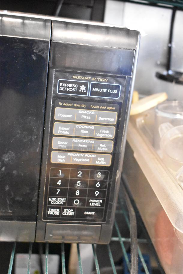 Sharp R-3A55 countertop microwave oven, black, with digital keypad for snacks, cooking, and reheating. 120 volts, 1 phase.