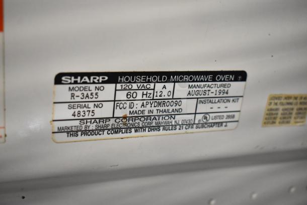 Sharp R-3A55 Microwave Oven label showing model, serial number, voltage, frequency, manufacture date, and FCC ID. Made in Thailand.