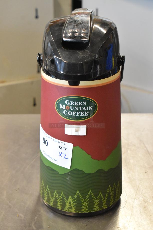 Green Mountain Coffee air pot, black lid, red and green body with logo, auction tag indicating quantity of 2.