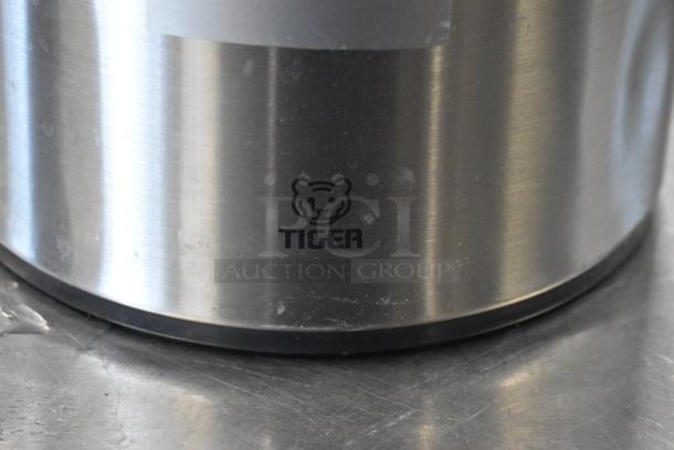 Stainless steel Tiger brand air pot with logo, shown in close-up. Durable design, suitable for keeping beverages warm.