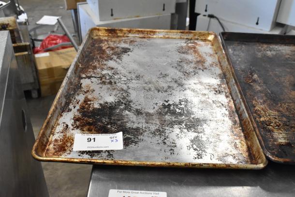 Three metal baking pans with visible use wear and patina. Auction label: Lot 91, QTY x3.