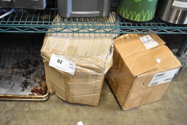 Two boxes on a shelf, one labeled for Acopa metal wire baskets and one for Dinex clear plastic bowls. Tags show auction info.