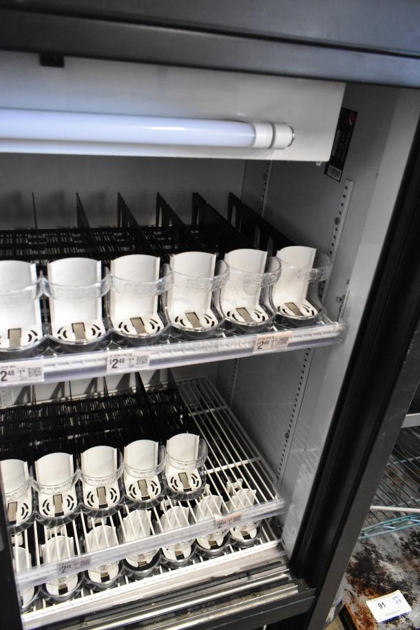 True GDM-41C-48 commercial cooler, two doors, poly-coated racks, 115 volts. Shows interior shelving and price labels.