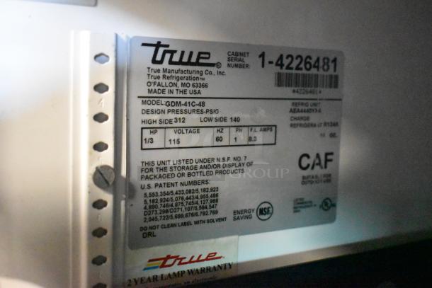 Label showing True GDM-41C-48 commercial cooler model, voltage 115, 1 phase, energy-saving NSF certification, 2-year warranty.