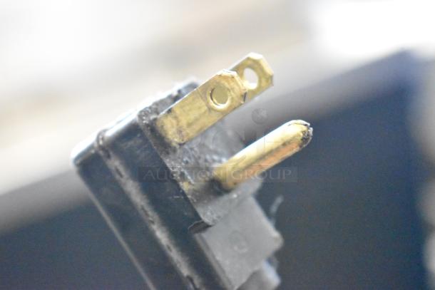 Close-up of the electrical plug of a Perlick BC48-1 commercial back bar bottle cooler, showing three prongs, slightly worn condition.