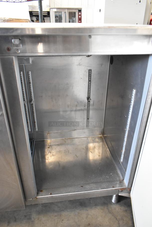 Perlick BS2DS stainless steel commercial 2-door undercounter cooler, open view, showing interior condition and shelf brackets.