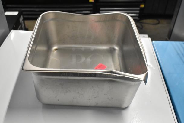 Stainless steel bin with dented rim, featuring a red label inside. Part of a lot including metal wire baskets.