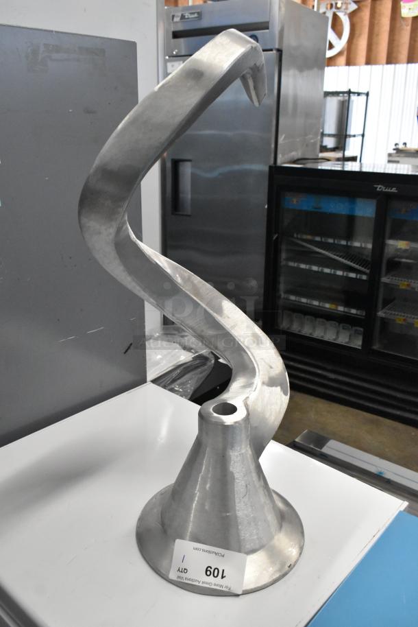 Metal commercial dough hook attachment for mixer, in good condition. Visible tag with auction number 109.