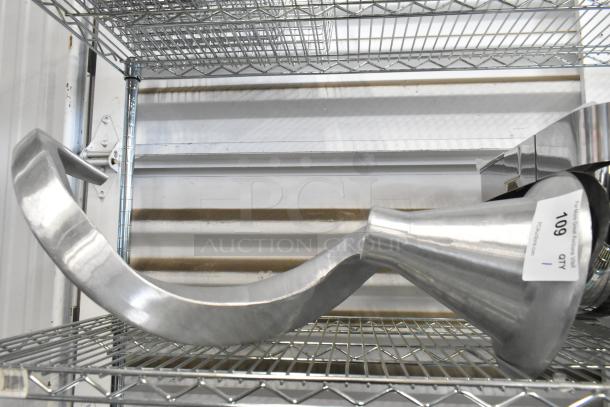 Metal commercial dough hook attachment for mixer, in excellent condition, visible label reads "109 QTY 1," stored on a metal shelf.