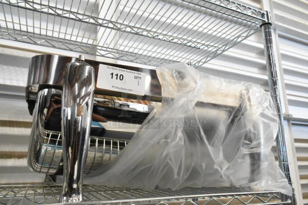 Metal chafing dish with rolling lid, lid stuck. Placed on wire shelf. Auction tag reading "110, Qty 1, PCIAuctions.com".