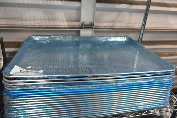 Stack of brand new perforated metal baking pans wrapped in plastic on a shelf, showcasing multiple units for auction.