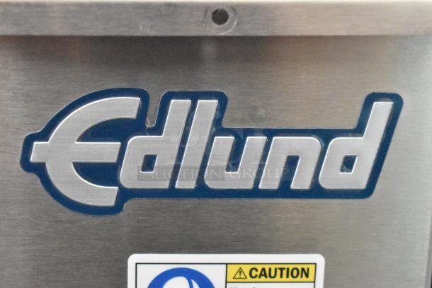 BRAND NEW SCRATCH AND DENT Edlund 610 Air Powered Crown Punch Can Opener, silver, with visible logo and caution label.