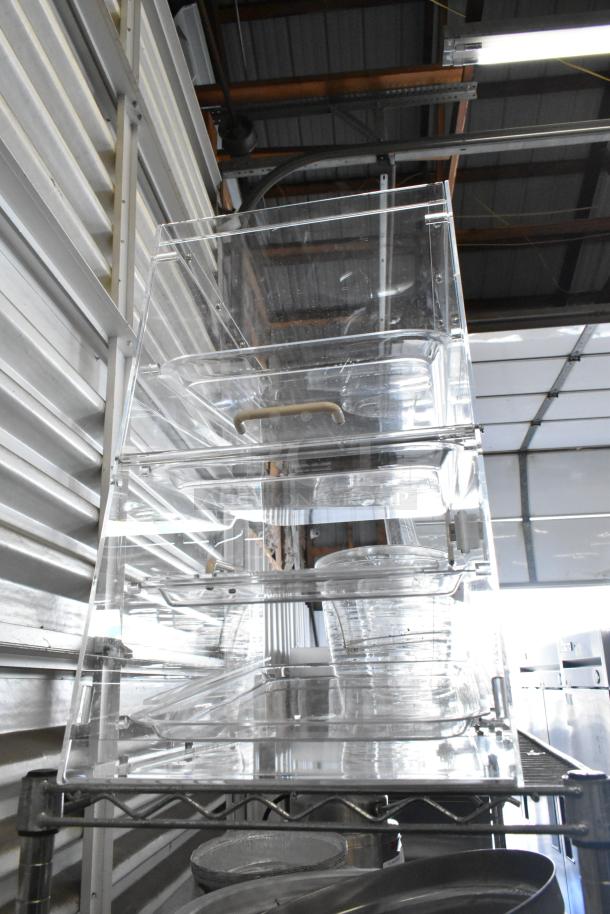 Brand new clear poly dry display case merchandiser. Features multiple shelves; minor scratches visible. Ideal for showcasing items.